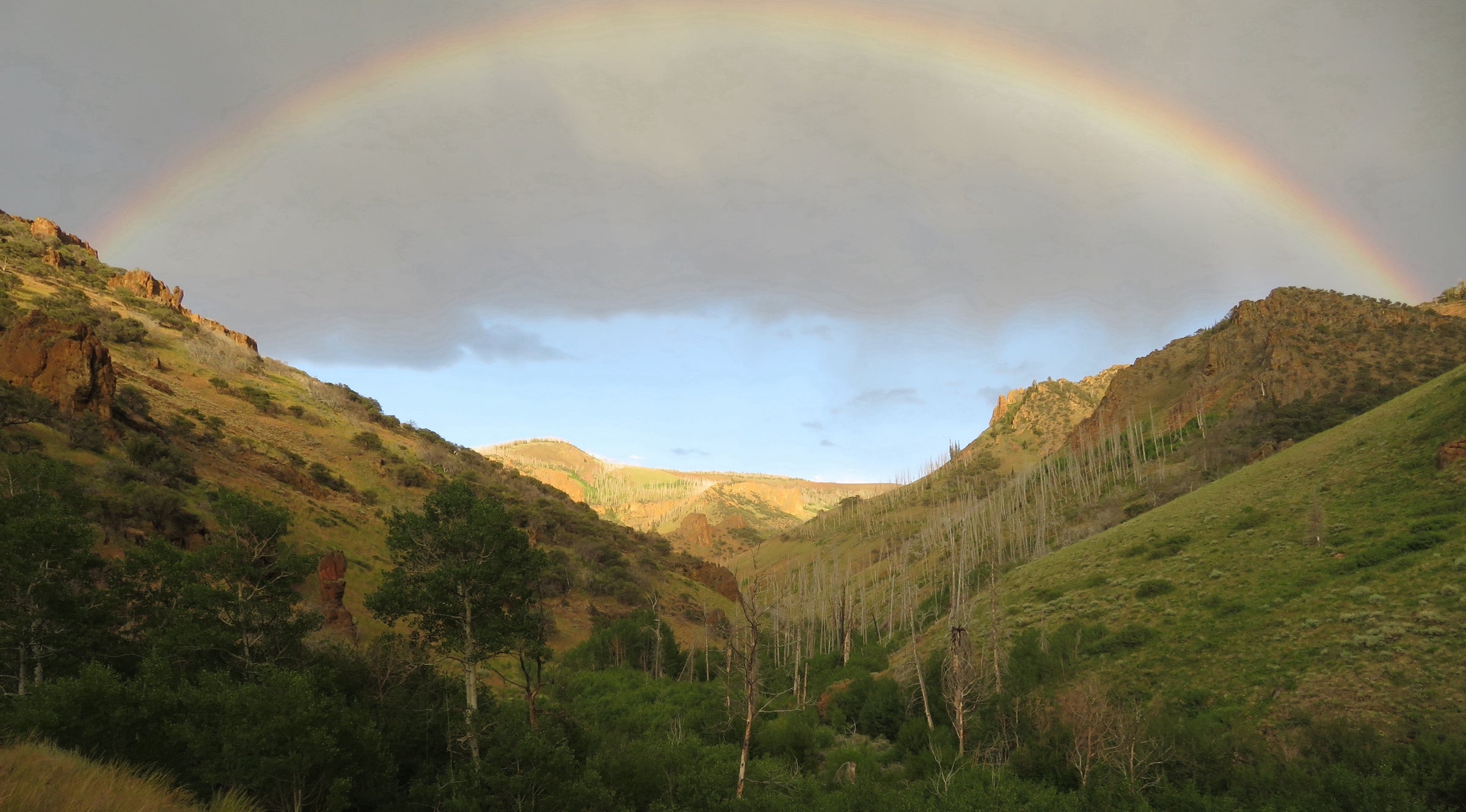 Rainbow arch over the mountains taken by Brendan McCullough